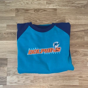 Dolphins sweatshirt  - Stor nfl tröja med laget dolphins. Super snygg och i ok skick. Ganska använd men fortfarande bra. Storlek Xl så väldigt mysig att ha på sig. Köpt på beyond retro för 360kr.