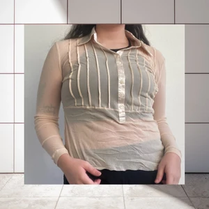Transparent blus i beige färg 😻 - Söt liten blus i ljust beige färg. Uppskattad till storlek M, men är väldigt stretchig. Blusen är transparent med silkesliknande detaljer och krage. Jag samfraktar gärna, ansvarar inte för postens slarv!