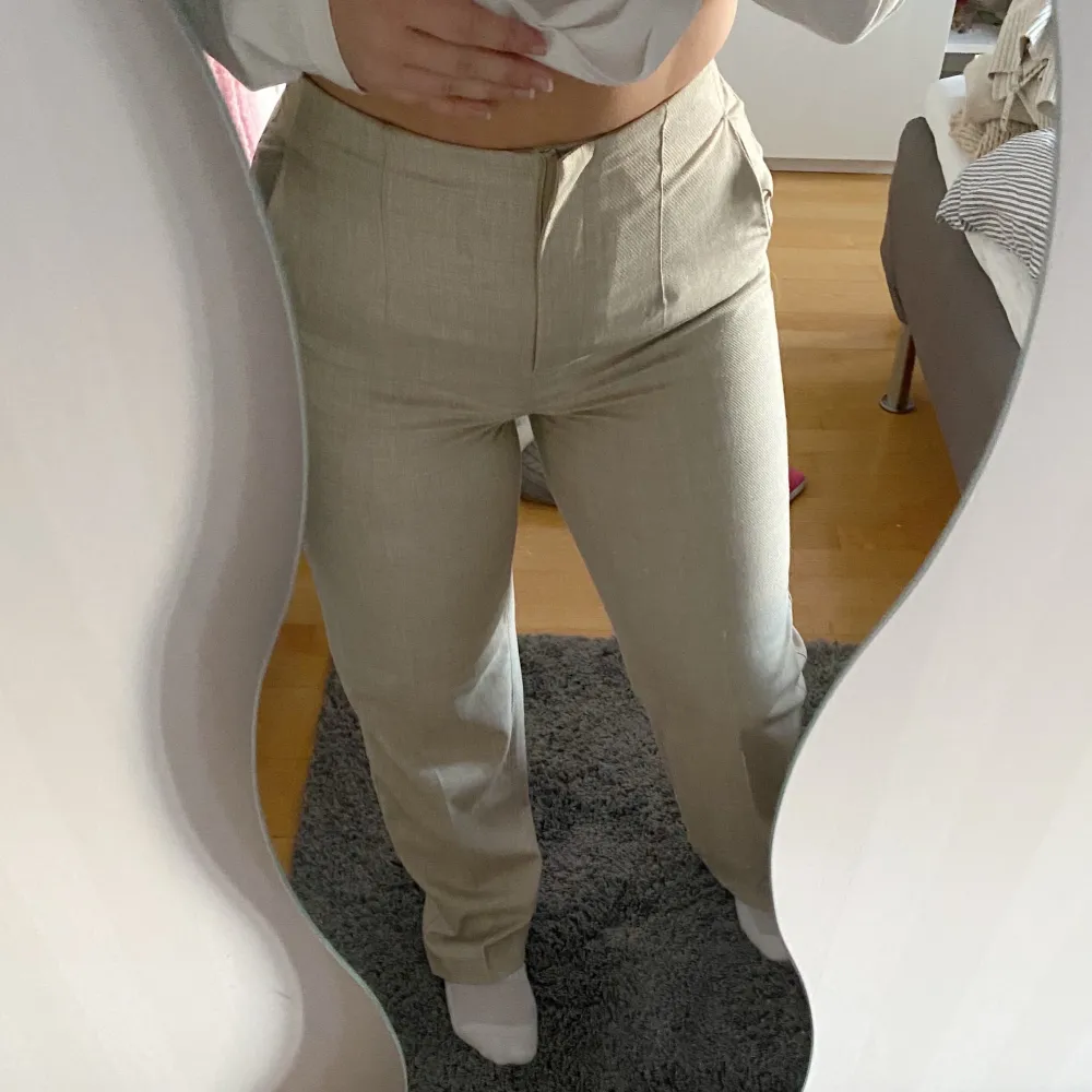 Beiga kostymbyxor i nytt skick från H&M. Inga fickor bak, endast låtsasfickor men finns fickor på sidorna. Storlek 36 passar mig som är 160cm, lite långa.. Jeans & Byxor.