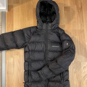 Dunjacka  - Svart dunjacka från peak i väldigt bra skick.                        Nypris 2500kr.                                                                   Storlek 170 junior