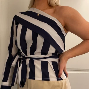 Topp - One shoulder topp! Så himla fin och använd fåtal gånger!🥰 Färgerna är marin blå och vit! Det finns även ett band för att markera midjan! +66kr frakt