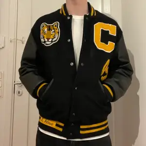 autentisk varsity/college jacka. Den är av väldigt hög kvalité då den har läderarmar och är vadderad så den är mycket varmare än vanliga varsityjackor av bara tyg. Köptes på beyond retro för 1 tusen förra året, och dom köper in vintage direkt från usa samt att lappen i nacken går att spåra till ett riktigt college i Ohio så den har en cool historia bakom (Made in USA, personen som jackan gjordes för namn står samt vilken sport han tävlade i på ryggen)! Sitter som en herr Medium, buda på! 