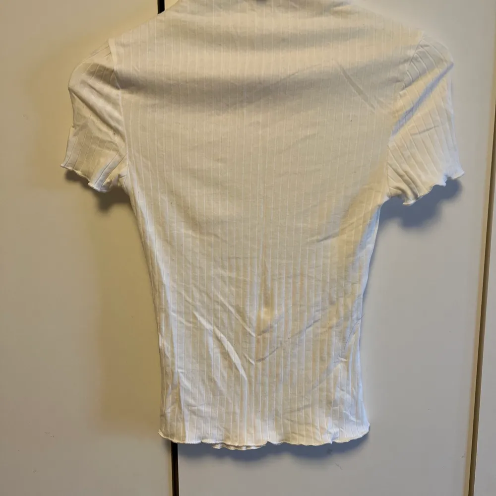 En enkel vit topp med krage. Väldigt stretchigt material. . T-shirts.