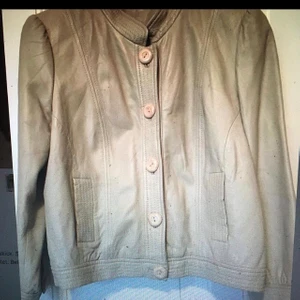 Beige skinnjacka Stockholm storlek 38 - Beige mjuk skinnjacka, märke:Stockholm, style name Blanche Jacket, storlek 38. Mycket mjuk, lite använd, i mycket gott skick, lammnappa, lite axelvaddar.
