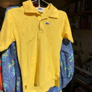 Pikéteöja från Lacoste - Gul och blå äkta vintage pikétröja från chemise lacoste, bra skick. OBS inga fläckar, det som syns på bilden är en skugga från mitt fönster haha. 