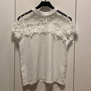En vit lite finare t-shirt med mesh och blommiga detaljer😊