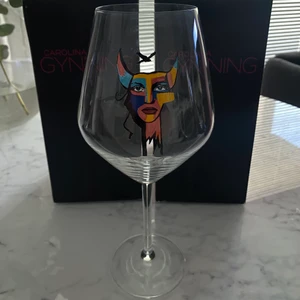 Rödvinsglas Carolina Gynning - Rödvinsglas från Carolina Gynning i motivet ”Protect me” rymmer 75cl. Helt oanvänt, har bara stått som prydnad.  Nypris: 249:-