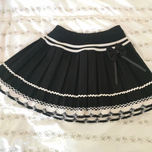 Kjol strl XS-S - Väldigt söt kjol köpt på plick. Storlek S. Har resår i midjan. 100% polyester, svart och äggskalsvit. Märket heter Innocent lifestyle. Rätt tjockt tyg. 35cm lång. 