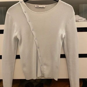 Långärmad tröja - Ribbad tröja med knappar som man kan öppna och justera