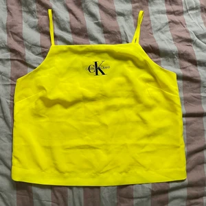 Gult Calvin Klein linne - Gult Calvin Klein linne i chiffong (kanske chiffongliknande?) i strl M, passar lite oversized på mig som har S. Reglerbara band och ett underlinne. Använd typ 2 ggr. Frakt tillkommer. 