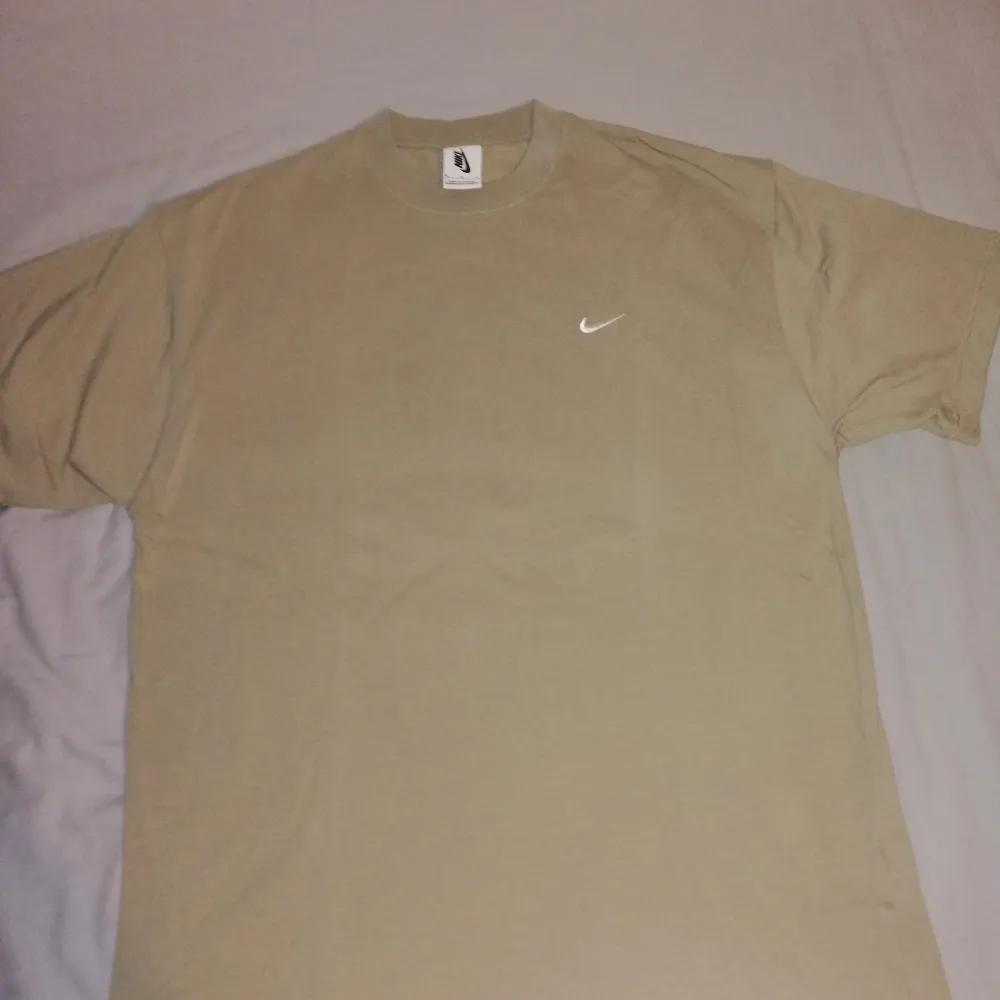 Nikelab tshirt i khaki färg med vit swoosh logga. I princip oanvänd. Tjockare kvalite. Strl Medium. T-shirten är slutsåld i Sverige. Fraktar genast vid köp, 45kr blåpåse eller 66kr spårbart till ombud. . T-shirts.