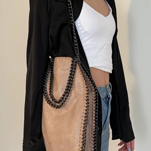 Oäkta Stella Mcartny väska i beige - Detta är en OÄKTA Stella Mcartny väska, men i bra skick då den knappt är använd. Väskan är i god kvalite, inga dragkedjor krånglar, sömmarn är fina.