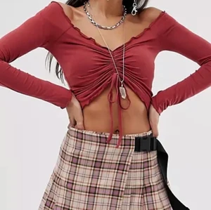 Tröja med knytning - Jättefin röd långärmad tröja med lite volang. Säljs på grund av att den är lite för stor för mig vid axlarna. Tröjan är i storlek M men passar mig som har S jättebra förutom axlarna. Den är superfin, både off shoulder och som en vanlig långärmad tröja. Köpt på Bershka och är slutsåld. Jättebra skick och inga slitningar, skriv för intresse💞💞