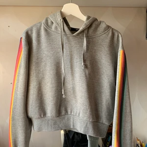Hoodie - Grå hoodie med regnbågar på ärmarna. Från bikbok och sparsamts använd🌶