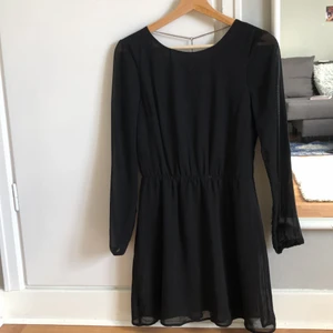 Klänning svart - Den här klänningen är fin, ganska kort, och är elastisk i midjan så den ger en lite av en hourglass-form. Den är öppen i ryggen och har en kedja därbak. Materialet är ett mesh liknande material som är semi-transparent men har en mer opak underkjol. Storleken anses vara xs, men jag påstår att den passar större storlekar då jag är en M.