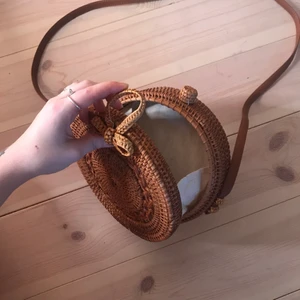 Axelväska i korg - En liten axelväska i korg material. Inköpt i Singapore. Använt sparsamt. Lågt pris pga möts ej upp utan skickar på post och köpare står för frakt! :)