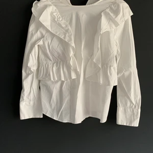 Blus med volang från Zara - Vit blus med volang i fint skick från Zara. Stl S. Köparen står för frakt.