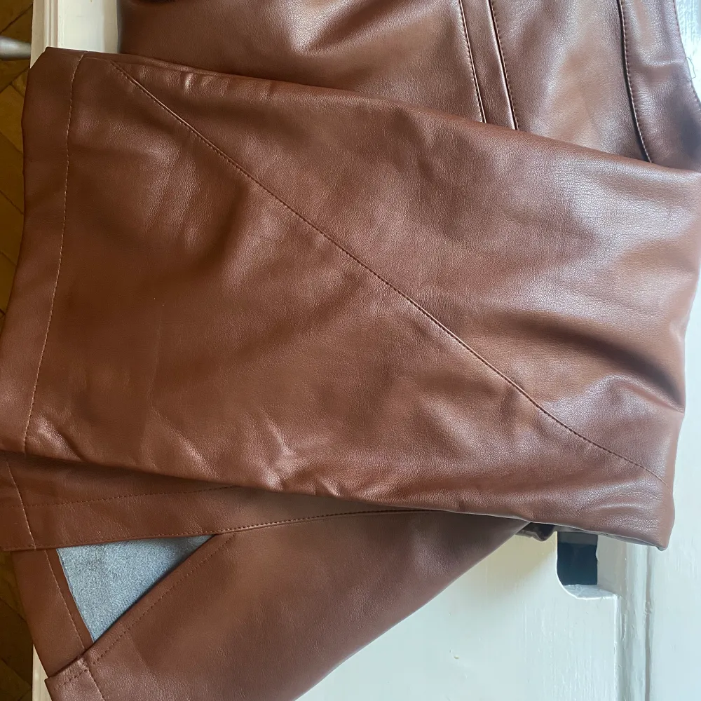 Från NA-KD. Använt fåtal gånger så väldigt bra skick. Fin brun färg med slit nertill. Storlek 38.. Jeans & Byxor.