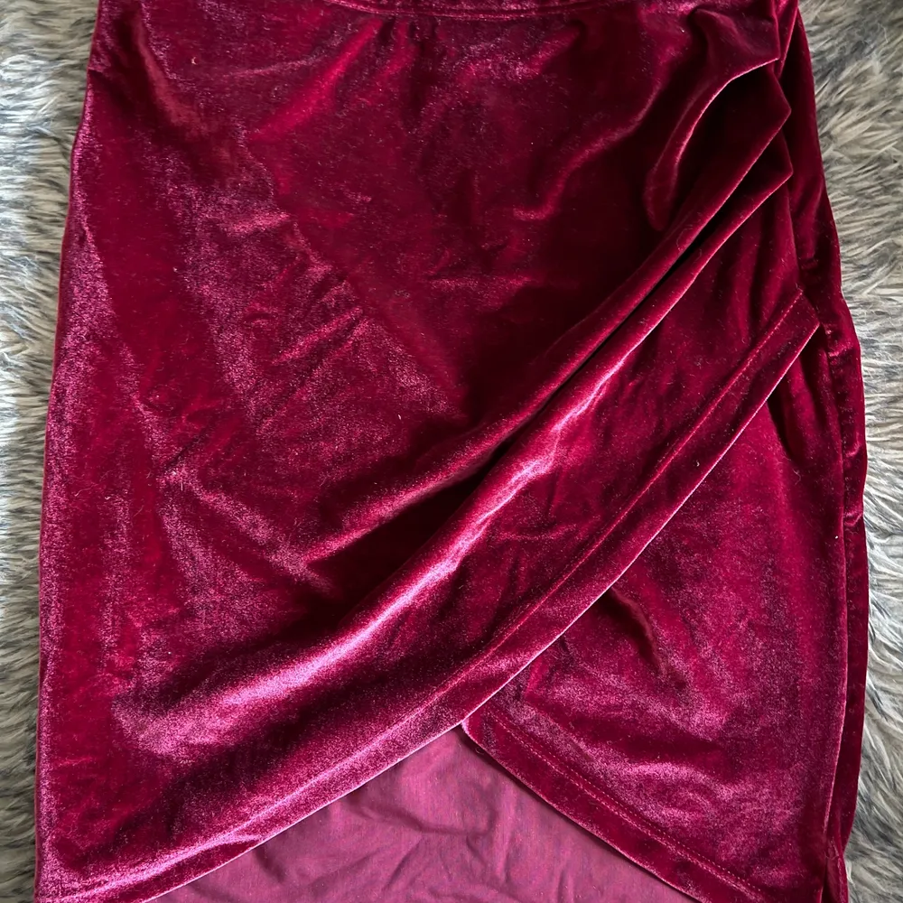 En vinröd kjol i sammet som jag använt en julafton. Väldigt fin och smickrande passform men som tyvärr blivit för liten för mig. Kjolen går i omlott framtill vilket gör att benen ser långa ut! . Kjolar.
