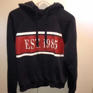 Hoodie Gina Tricot  - Marinblå hoodie med vitt och rött tryck frå Gina Tricot. Mycket fint skick. Strl S