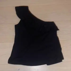 One shoulder linne med volang i svart