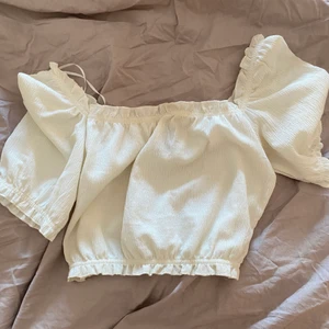 Topp - Creme vit topp som man kan bära både off shoulders eller på axlarna. Volang detaljer. Sjukt söt!! Inga defekter 
