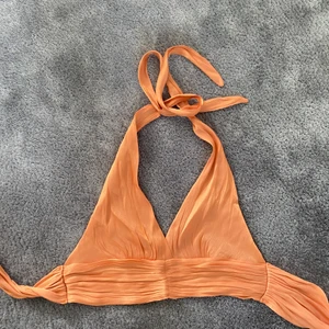 Orange topp - Oanvänd, skimmrigt material i fin orange färg. 