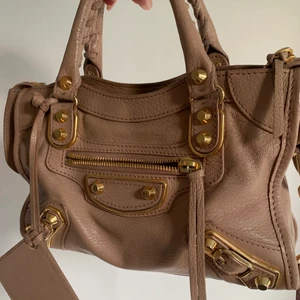 Balenciaga city bag mini - Fin äkta väska från Balenciaga, köpt förra året och i väldigt fint skick! Lägger upp för intressekoll!!! Färgen är ”powder pink” med gulddetaljer. Kvitto finns