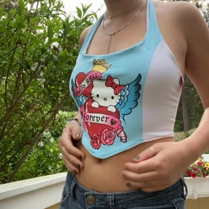 Tröja - Korsett inspirerad topp jag sytt med hello Kitty tryck på med knyte i halsen. Skulle säga att det är en storlek S. Frakt 24kr🥰