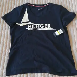 Säljer Tommy Hilfiger T-shirt. Helt oanvänd med prislapp kvar. Orginalpris $39,50 och säljs för 200 kr. 