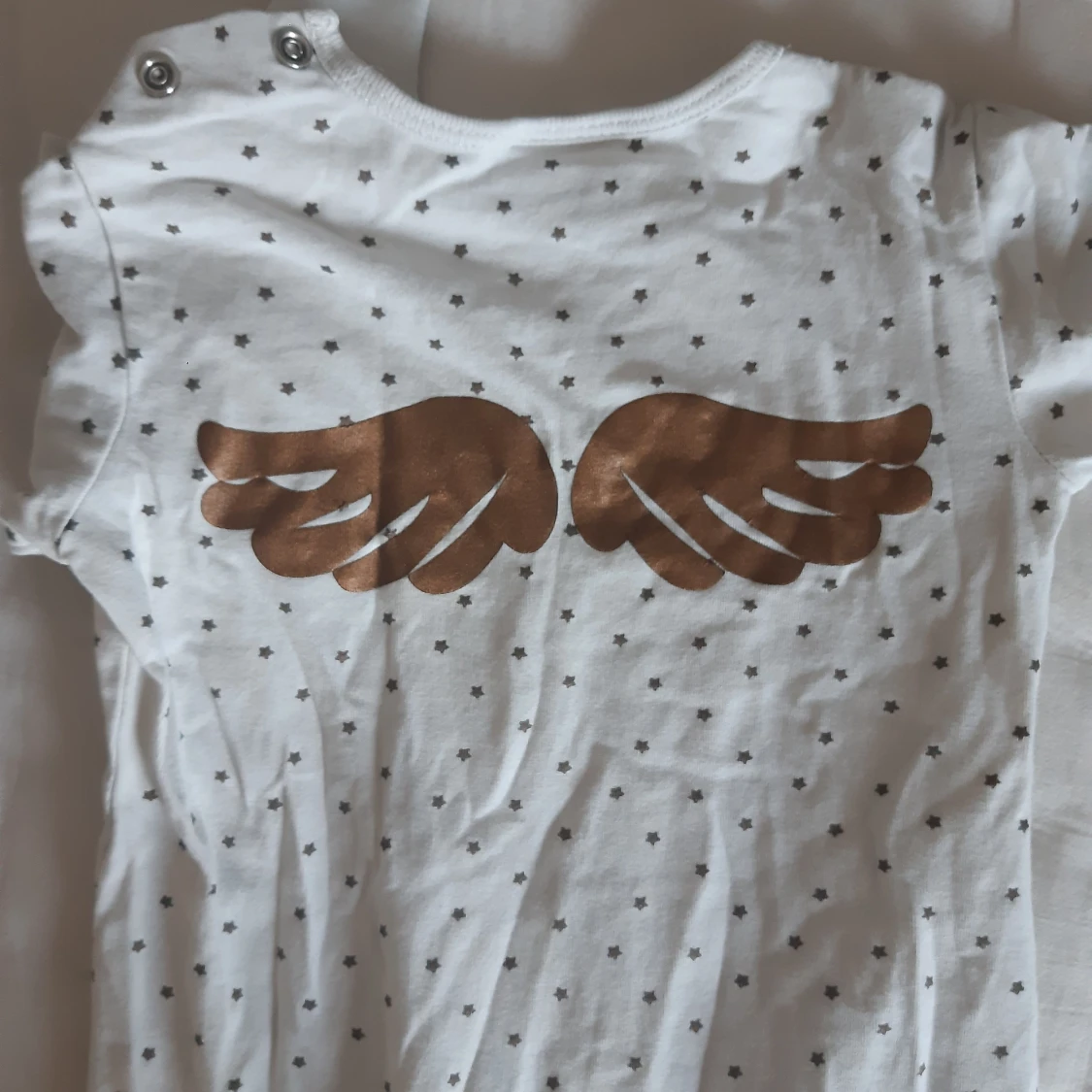 Vit pyjamas med stjärnor, vingar samt text från Baby Lindex - 90