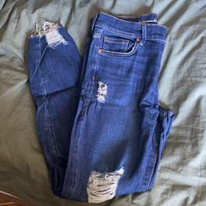 Mörkblå Jeans från Never Denim, slitningar längst ner och på båda knäna, väldigt stretchiga i materialet!😍 Storlek M, ca 37 cm breda i midjan men kan gå ut till 40cm. Längd ca 90cm. Väldigt lite använda!💞