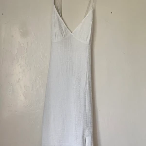 Vit klänning  - Köpt på H&M, har aldrig använt, vit med korsad rygg. Ner till lite över knäna 