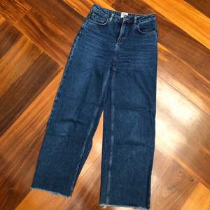 Blue denim with wide legs and high waist. Legs are a bit cropped and have frayed ends. Good condition.