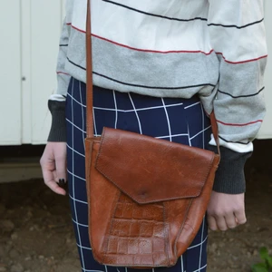 Brun väska  - Brun axelväska. Köpt secondhand. Superfint krokodilmönster i mitten på väskan. Rymlig 