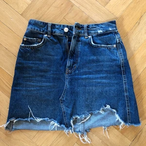 Jeanskjol Gina Tricot strl 34 - Jeanskjol från gina tricot med slitningar. Storlek 34, hög midja. 