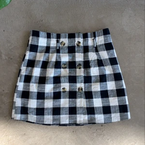 Rutig kjol - Kjol i stolek 40 men passar lika väl på stolek 38! Härlig sommarkjol i rutat mönster med knappar framtill. Kommer vara perfekt för sommaren:) 