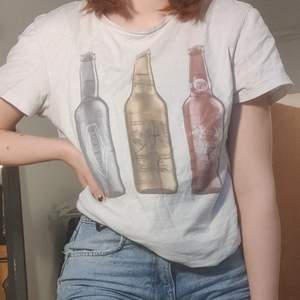 En t-shirt med flaskor som tryck! Inga hål eller andra fel på tshirten alls. Frakten är inkluderad i priset ✨