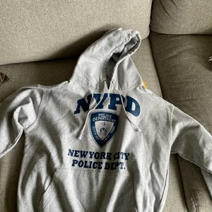 Grå hoodie med NYPD tryck, från beyond retro - Bra skick, storlek M på plagget men uppskattar riktiga storleken till XS herr.