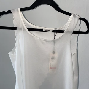 Vittlinne  - Vitt lite genomskinligt linne från Only med fin rygg i storlek S. Aldrig använd med prislappen kvar.