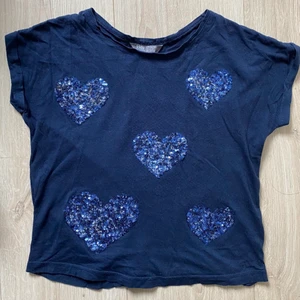 Blåa tröja med hjärtan - Blå tröja med hjärtan från Lindex, paljetterna har tappat lite färg men annars är den i fint skick, tror den är köpt på barnavdelningen men det är typ en XS :) frakten är inräknad i priset