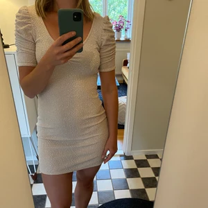 H&M glitterklänning med puffärm - Stretchig festklänning med u-ringning fram och bak. Strl M. Använd ett fåtal gånger. Väldigt mjuk och följsam. Superfin