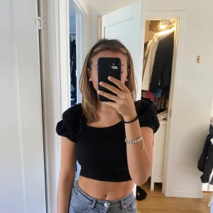 Svart topp - Svart topp från ginatricot i storlek xs, använd fåtal gånger. Stretchigt matrieal med puffärmar. Kan bäras på olika sätt som ni kan så på bilderna.