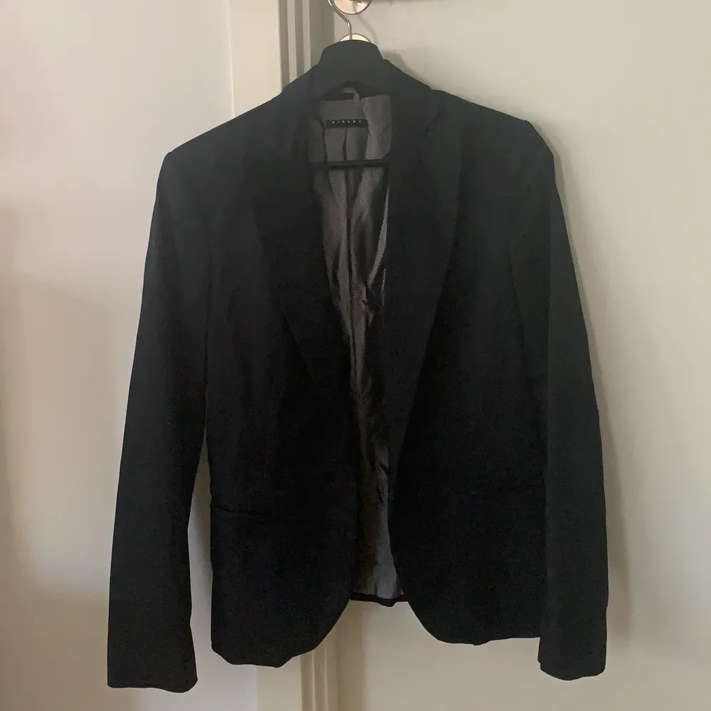 Black blazer from Sisley, an Italian brand with good quality items. Good for office or for an evening out, pretty comfortable and in good shape. The collar like this I have never seen it anywhere, so it is special in its way! Size 44 indicated but fits as an S/M . Kostymer.
