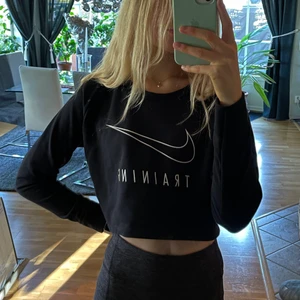 Nike Croptop träningströja - Säljer en supersnygg svart långärmad croptop från Nike.   Använd fåtal gånger🌸Ryggen är i nät vilket gör den väldigt luftig och skön att använda vid träning😚