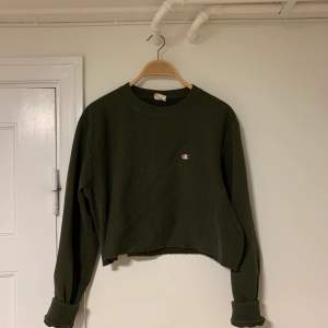 En croppad sweater från Champion i mossgrönt, strl. S.