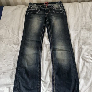 Mörkblå jeans med snygga detaljer - Lågmidjade bootcut jeans i mycket fint skick, storlek xs/s.