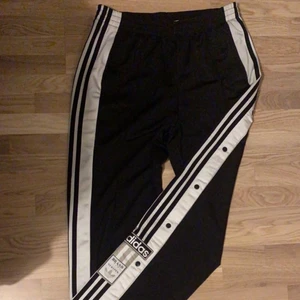 Adidas popper pants - Dessa har tyvärr blivit för små med tiden när de legat långt bak i garderoben. Väldigt bekväma svarta (tränings)byxor från adidas med street stil, 70-tal. Knappar längst sidorna förutom de sista två längst upp vid höften som är ”fejk”knappar. Finns även snörning vid midjan på insidan. 