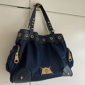 Marinblåa väska från Juicy Couture! - Supersnygg väska från Juicy Couture! Köpt för några år sedan men knappt använd så väskan är i väldigt fint skick! Nypris cirka 2300kr, buda privat från 600kr! Köparen står för frakten på 66kr! 💗💙💙