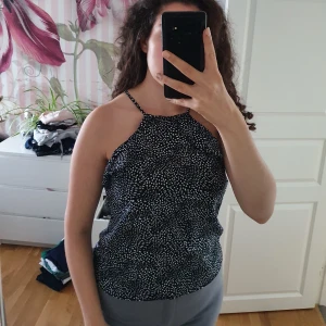 Topp svart prickig - Jättefin topp, linne med volang som inte används. Perfekt till sommaren.